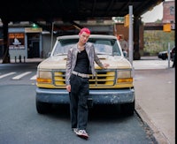 a young man leaning against a yellow truck