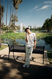 a man sitting on a bench in a park