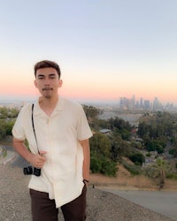 a man standing on top of a hill with a camera in his hand