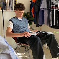 a young man sitting in a chair reading a book