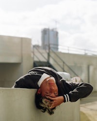 a skateboarder laying on a concrete wall