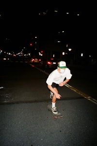 a man riding a skateboard on a city street at night